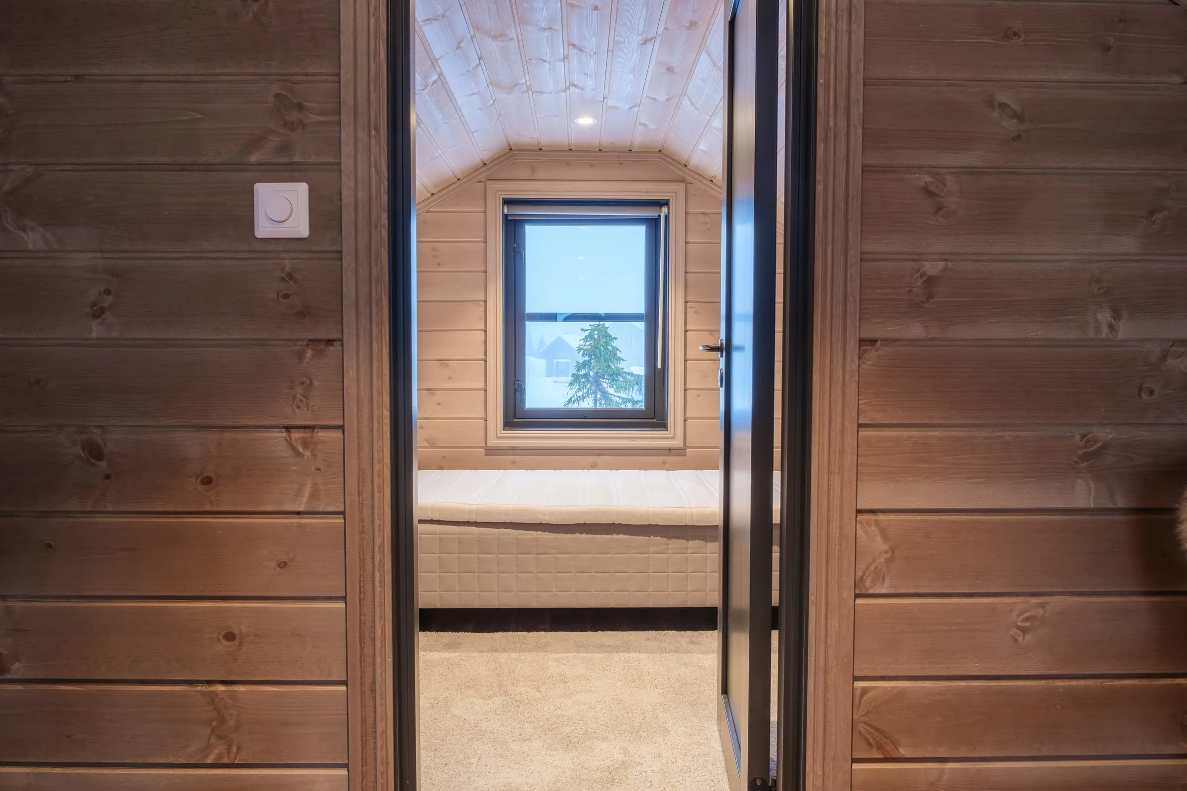 Warm bedroom with reading lamps and a framed reindeer print above the bed