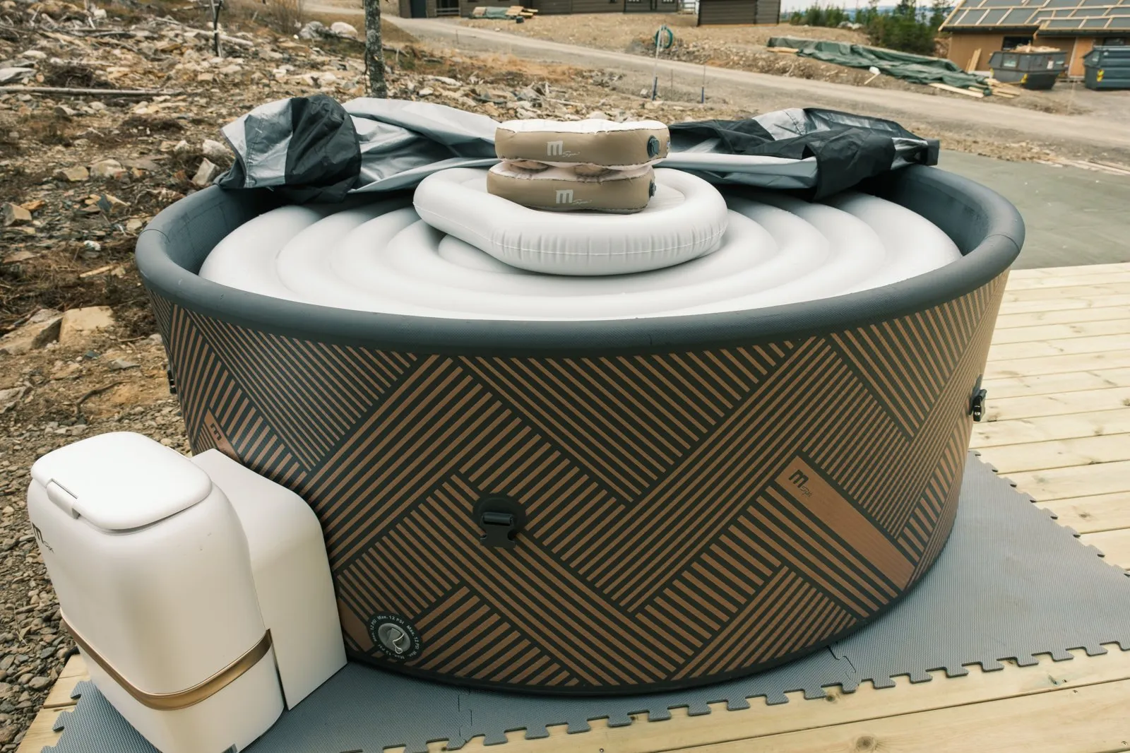 The private MSpa hot tub on its deck mat, with the inflatable cover and head rests